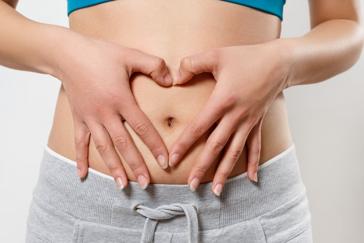 woman shows two hands gesture heart on his stomach. on white. Concept of women's health, early pregnancy